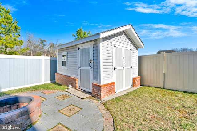 view of shed with an outdoor fire pit and a fenced backyard