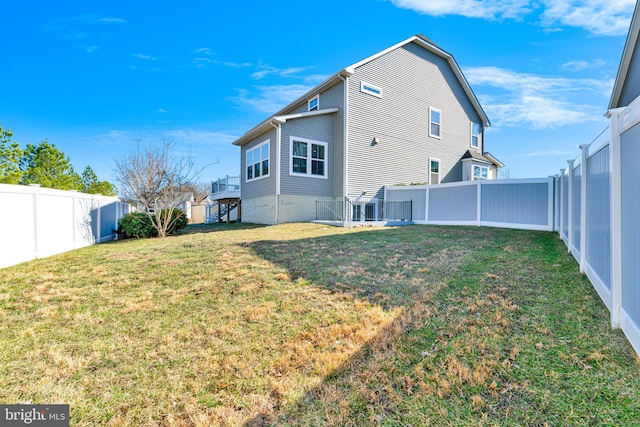 back of house with a yard and a fenced backyard