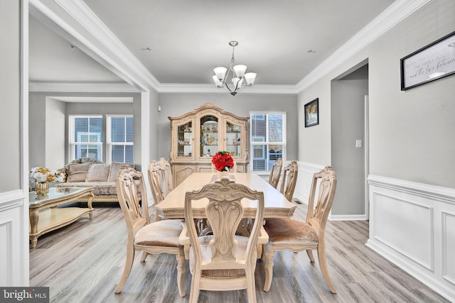 dining space with plenty of natural light, a notable chandelier, and ornamental molding