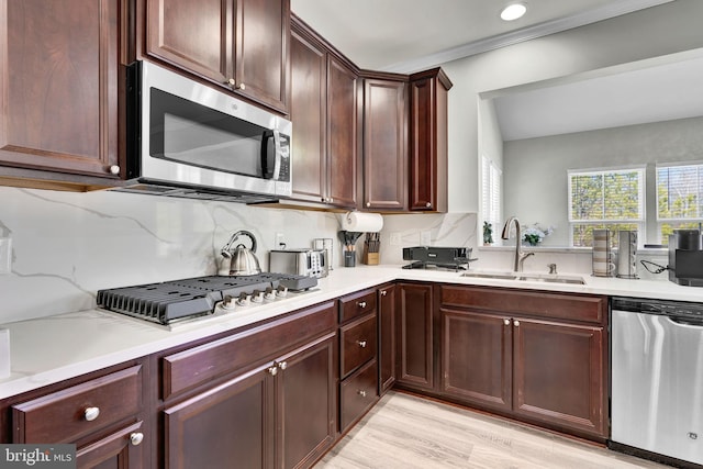 kitchen featuring decorative backsplash, appliances with stainless steel finishes, light countertops, and a sink