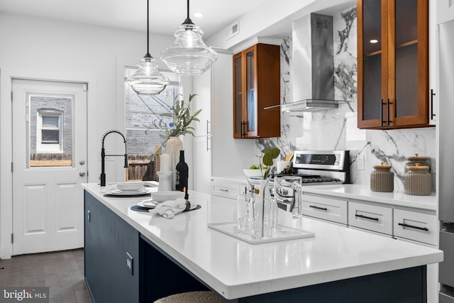 kitchen with stainless steel range with gas cooktop, light countertops, visible vents, decorative backsplash, and wall chimney range hood