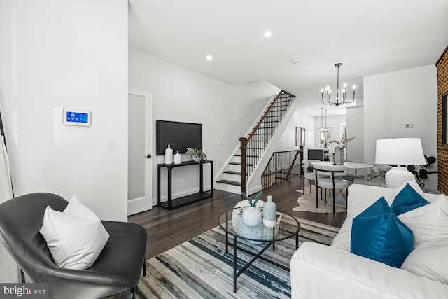 living room featuring an inviting chandelier, stairway, wood finished floors, and recessed lighting