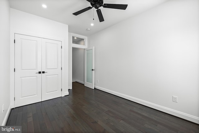 unfurnished bedroom with a closet, baseboards, dark wood-type flooring, and recessed lighting