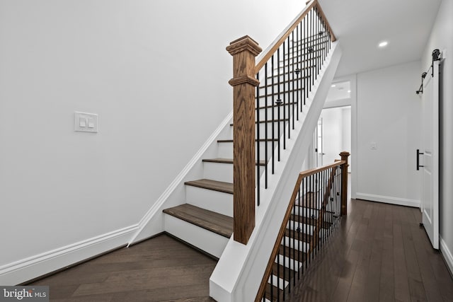 stairs with a barn door, baseboards, hardwood / wood-style floors, and recessed lighting