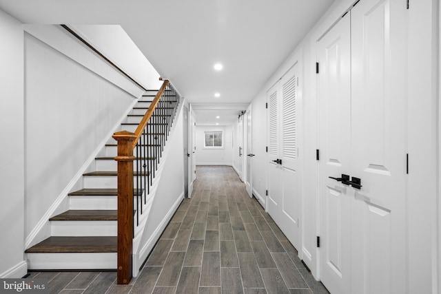 corridor with recessed lighting, stairs, baseboards, and wood finish floors