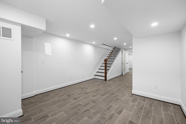 finished below grade area with recessed lighting, wood finished floors, baseboards, and stairs