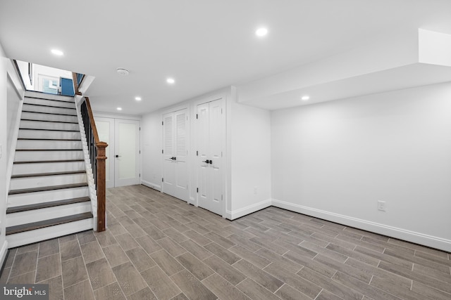 finished below grade area with baseboards, stairway, wood finished floors, and recessed lighting