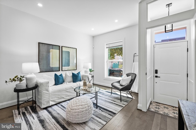 living area with baseboards, dark wood-type flooring, and recessed lighting