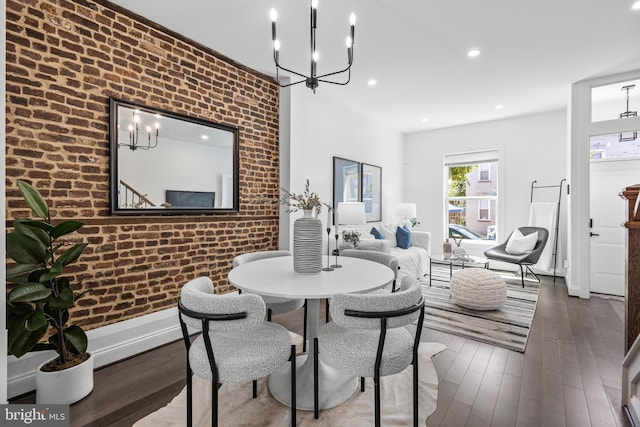 dining space with brick wall, baseboards, wood finished floors, and recessed lighting