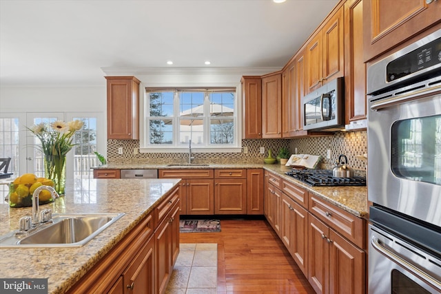 kitchen with a sink, decorative backsplash, appliances with stainless steel finishes, and crown molding