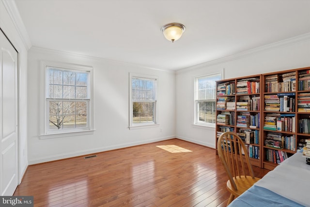 bedroom featuring visible vents, ornamental molding, a closet, light wood finished floors, and baseboards