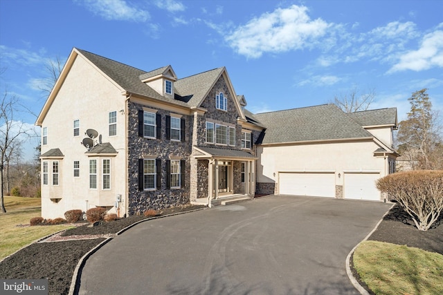 view of front of house featuring aphalt driveway, an attached garage, stone siding, and stucco siding