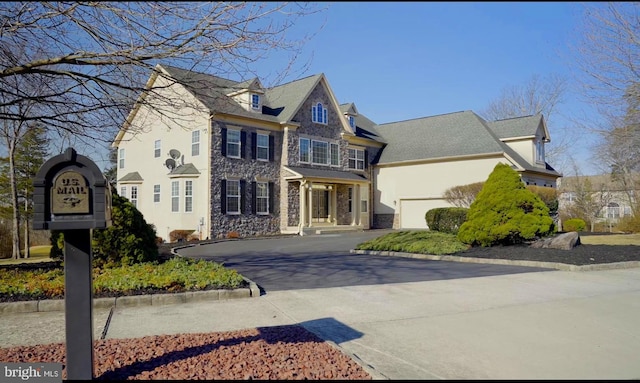 view of front of home featuring stone siding, driveway, and stucco siding