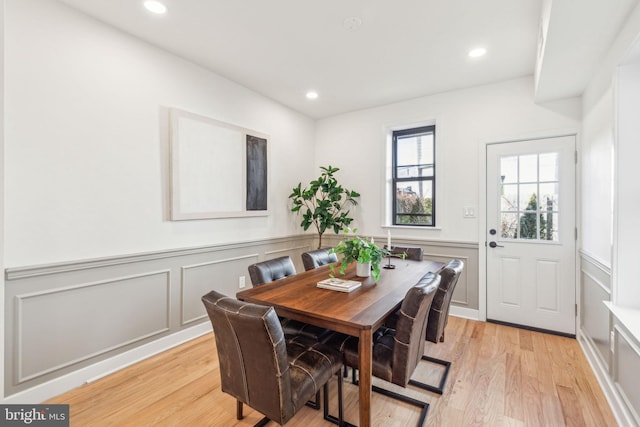 dining area with recessed lighting, wainscoting, a decorative wall, and light wood finished floors