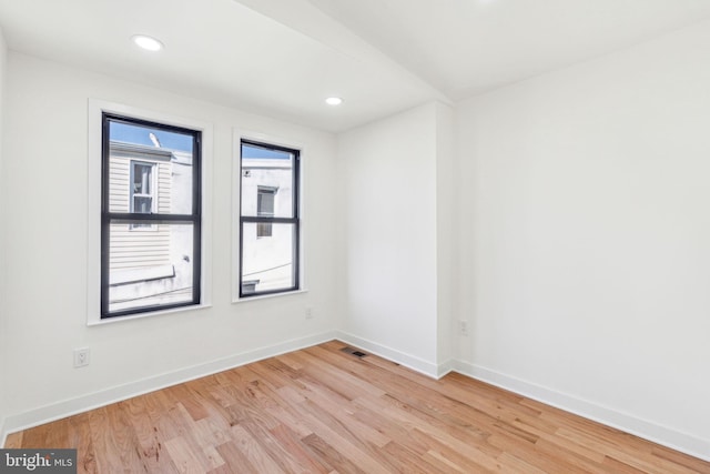 unfurnished room with recessed lighting, baseboards, visible vents, and light wood finished floors