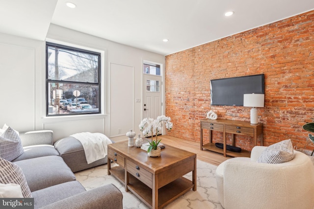 living room featuring recessed lighting and brick wall