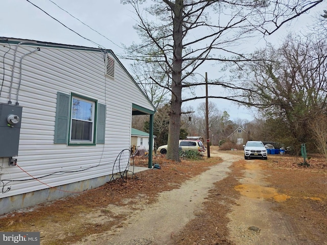 view of property exterior with dirt driveway