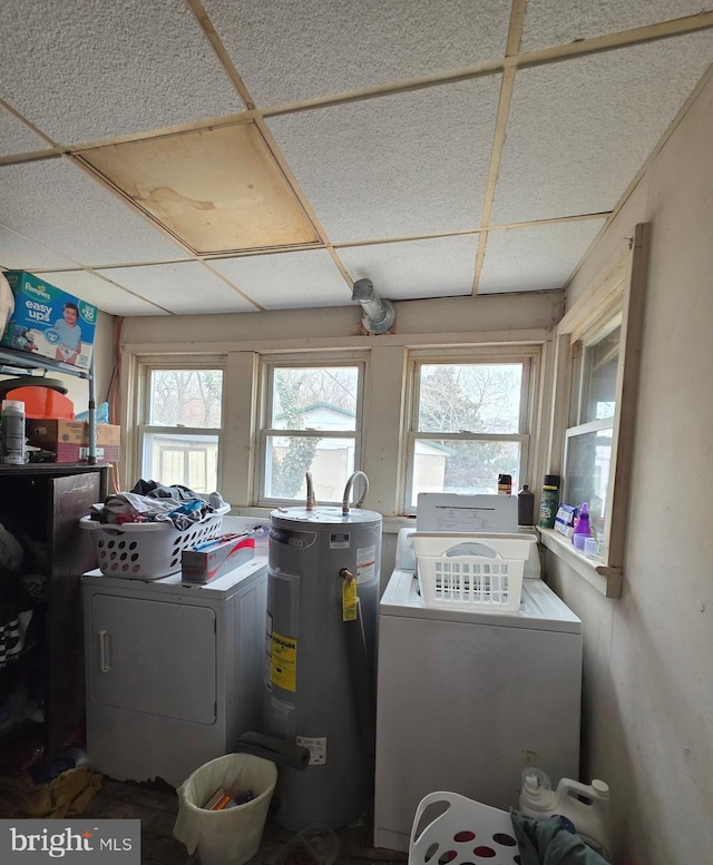 laundry room with washer and dryer, laundry area, water heater, and a healthy amount of sunlight