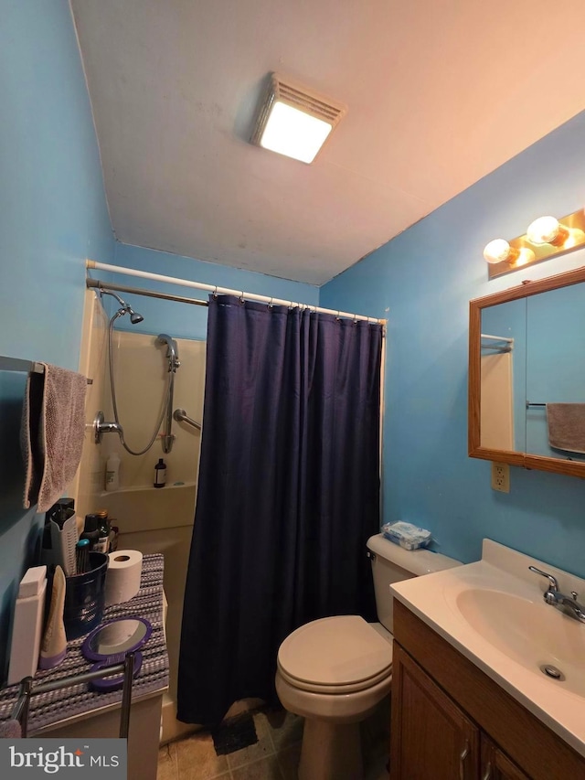 bathroom featuring toilet, curtained shower, and vanity