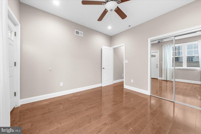 unfurnished bedroom featuring recessed lighting, wood finished floors, visible vents, baseboards, and a closet