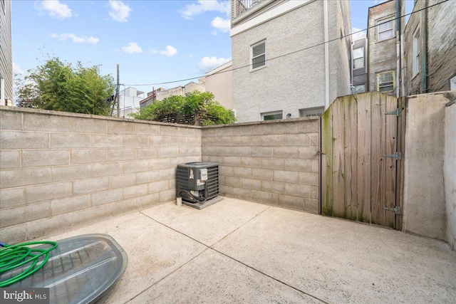 view of patio / terrace with a gate, fence, and central air condition unit