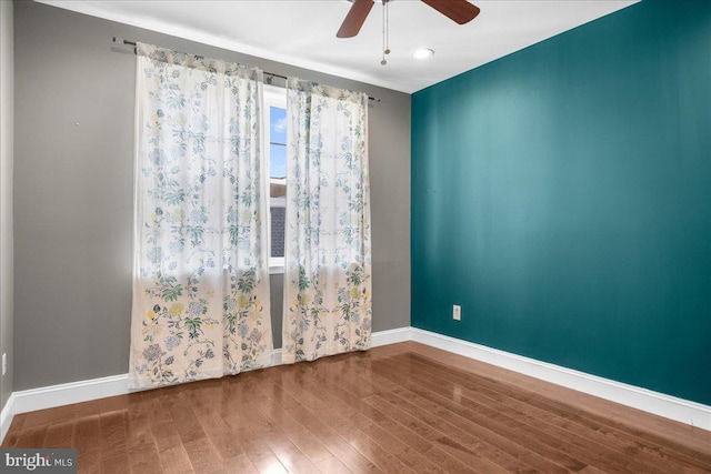 spare room with ceiling fan, baseboards, and wood finished floors