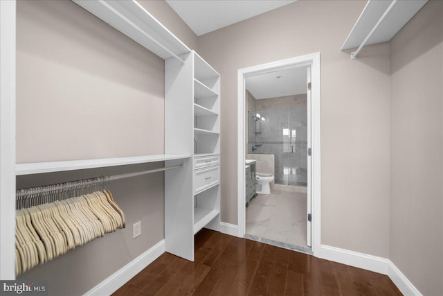 walk in closet with wood finished floors