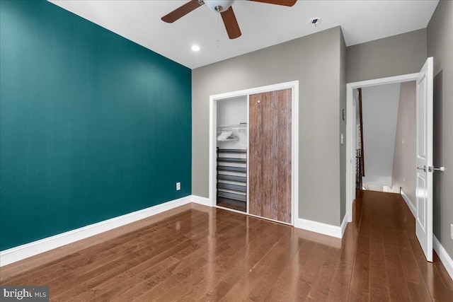 unfurnished bedroom featuring a closet, ceiling fan, baseboards, and wood finished floors