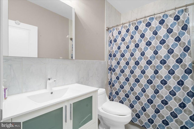 bathroom with curtained shower, vanity, toilet, and tile walls