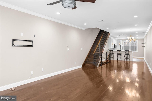 interior space with baseboards, ornamental molding, wood finished floors, stairs, and recessed lighting