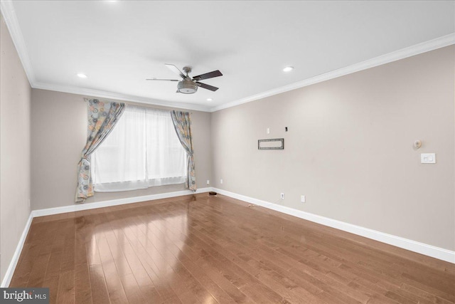 spare room featuring ceiling fan, crown molding, baseboards, and wood finished floors