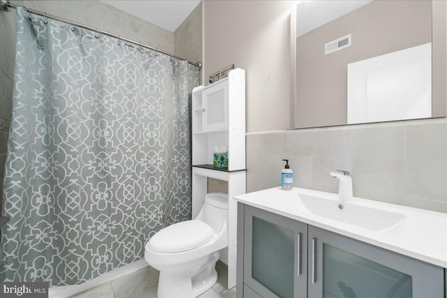 bathroom with curtained shower, toilet, vanity, visible vents, and tile walls