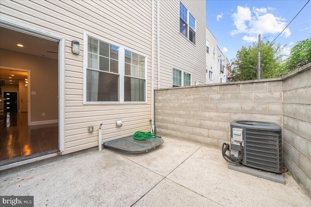 view of patio featuring central AC and fence