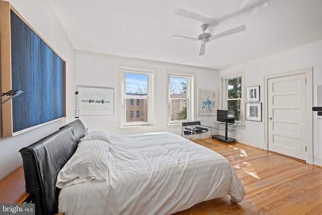 bedroom featuring ceiling fan, wood finished floors, and baseboards