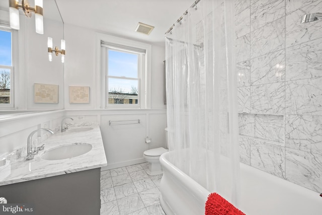 full bathroom with marble finish floor, a sink, toilet, and double vanity