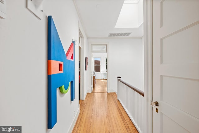 hallway with light wood-style flooring and visible vents