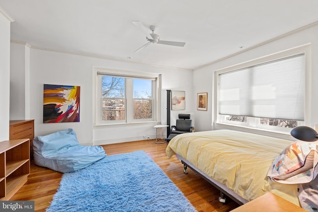 bedroom with ornamental molding, ceiling fan, and wood finished floors