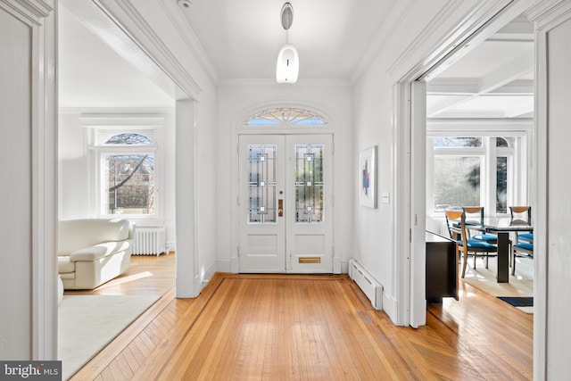 foyer with a baseboard heating unit, light wood-style floors, ornamental molding, and radiator heating unit