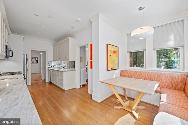 kitchen with breakfast area, ornamental molding, freestanding refrigerator, light wood-type flooring, and baseboards