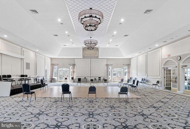 kitchen with a high ceiling, visible vents, and white cabinets