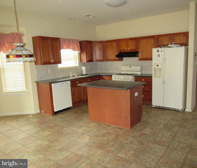 kitchen featuring dark countertops, white appliances, a sink, and under cabinet range hood