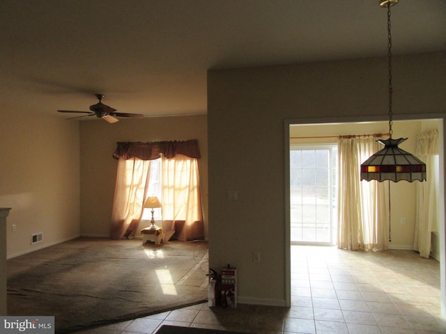 living area with visible vents, a ceiling fan, and light tile patterned flooring