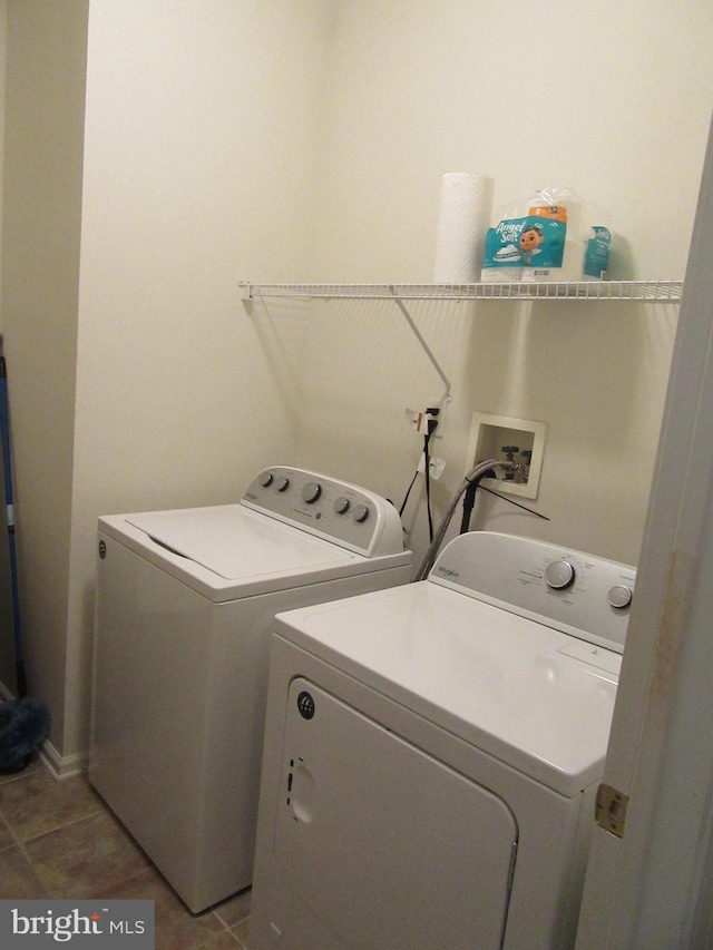 clothes washing area featuring tile patterned floors, laundry area, and separate washer and dryer