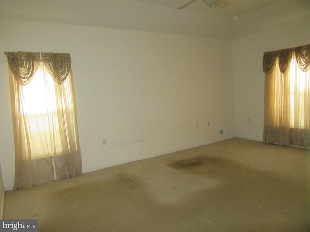 carpeted empty room featuring a ceiling fan