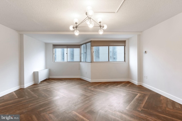 spare room with baseboards, plenty of natural light, and a notable chandelier