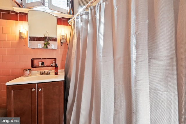 bathroom with vanity and tile walls