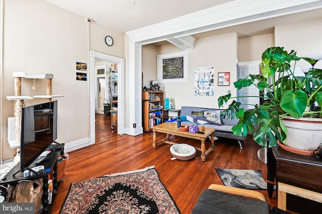 living area featuring a fireplace, baseboards, and wood finished floors