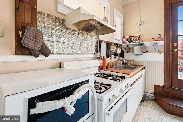 kitchen featuring light countertops, gas range gas stove, and under cabinet range hood