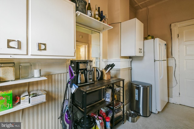 kitchen featuring white cabinets and freestanding refrigerator