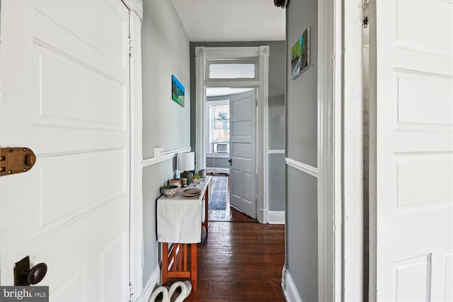 hall featuring dark wood-type flooring and baseboards